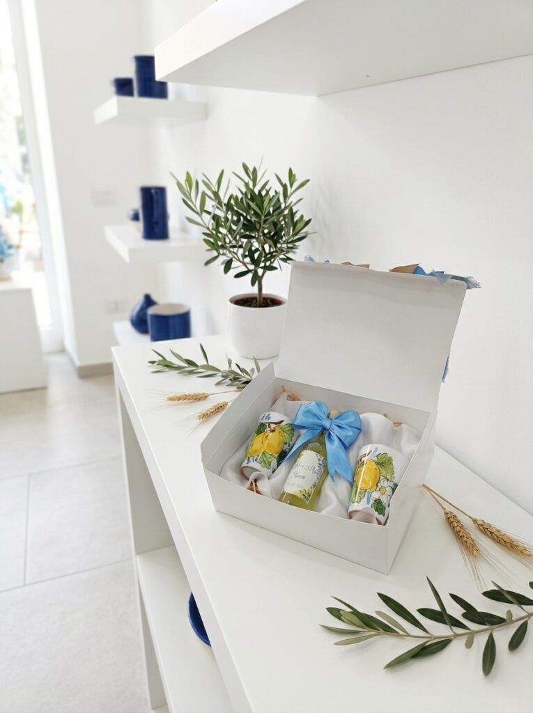 Gufo in ceramica artigianale decorato a mano esposto su mensola bianca con dettagli botanici