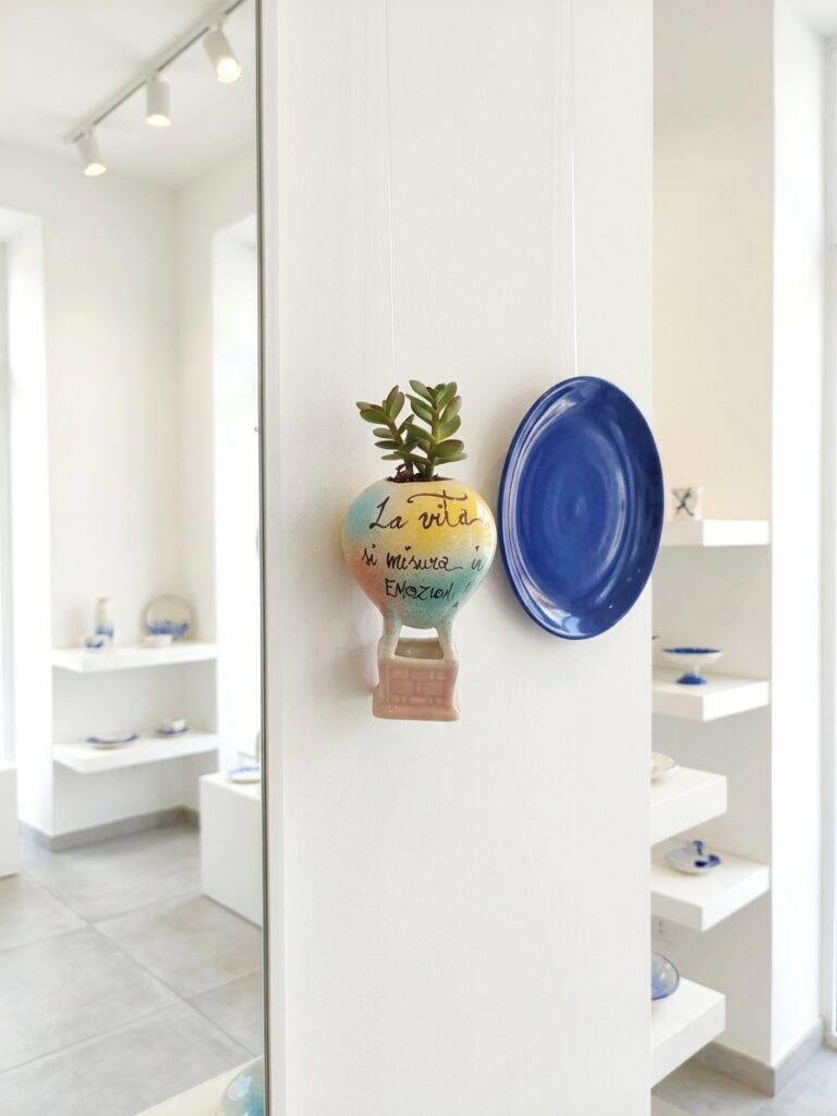 Mongolfiera in ceramica con frase motivazionale appesa alla parete dello showroom